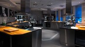 Uma cozinha moderna de aço inoxidável com várias estações de trabalho e fogões