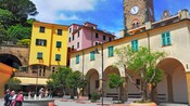 Una plaza rodeada de edificios medievales y un campanario