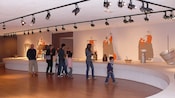 Young and old visitors look at a display of items and illustrations of cheese making