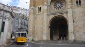 Um teleférico vintage leva passageiros em frente a uma velha igreja
