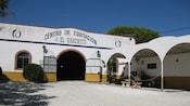 A building with a sign that reads Centro De Equitacion El Ranchito