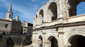 An amphitheater near old buildings, people and stairs