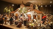 A village scene of an outdoor marketplace back in the 1700s with a crowd of figurines purchasing and selling goods