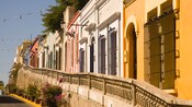 A row of colorful residences behind a stone railing raised above street level