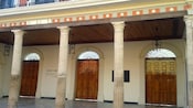Exterior of a theater featuring columns, doors and more
