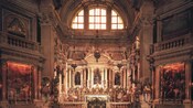 Un altar de iglesia espléndidamente decorado con óleos, estatuas de santos y santuarios con lámparas ornamentales