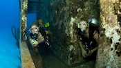 Two scuba divers explore a wreck