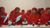 A group of Guests dressed in bibs and hairnets in a chocolate making class