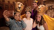 3 women and a man pose in costumes and headdresses