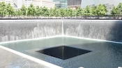 Water pours from the top of walls surrounding a large, square shaped hole in the ground