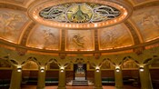 An ornate room with a statue of an angel in the center of the ceiling surrounded by frescoes of angels
