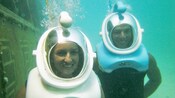 Smiling swimmers wearing Sea TREK diving helmets