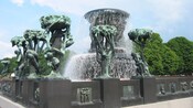 A sculpture, The Fountain, features trees intertwined with human figures symbolizing stages of human life