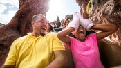 An excited little girl uses Mickey mitts to cover her eyes on Splash Mountain
