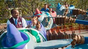 A VIP guide enjoys Dumbo the Flying Elephant with a little girl