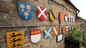 A collection of coat of arms adorns a stone wall at Corfe Castle