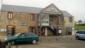 Cars in front of a building featuring a prominent sign that says CHARMOUTH HERITAGE COAST CENTRE, FINE FOUNDATION EDUCATION CENTRE