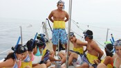 A bordo de un bote, un guía explica a varios buzos cómo utilizar sus chalecos salvavidas