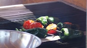 Pimentas e tomates cozinhando na grelha