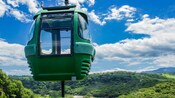A gondola hovers over a verdant hillside