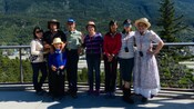 Un guía turístico disfrazado posa con una familia y, al fondo, se ven montañas boscosas