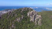 A mountain range that overlooks a crowded harbor and a populated peninsula