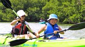 A mother and son paddle together in a kayak