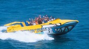 Passengers wave from a speedboat painted to look like a shark