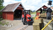 Una mujer adulta y dos niños paseando en un tractor por una vía
