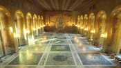 A mural in a hall lined with seats and pillars