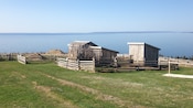 Fenced off structures in an outdoor area overlooking a large body of water