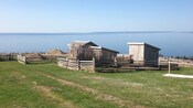 Fenced off structures in an outdoor area overlooking a large body of water