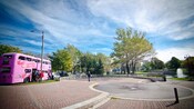 In a park, people board a pink bus that belongs to the Canadian Cancer Foundation