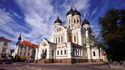 An ornate church with decoratively arched roofs and towers topped by onion domes and orthodox crosses