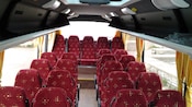A minibus interior with 4 fabric seats in the back row and an aisle flanked by seats of 1 and 2 per row