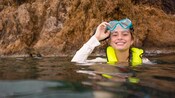 A girl smiles as she emerges from snorkeling