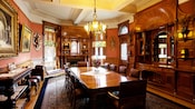 Uma sala de jantar formal do final do século XIX com um lustre, poltronas de couro e armários de madeira embutidos