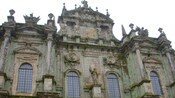 Uma antiga construção de pedra adornada com estátuas e molduras decorativas cobertas de musgo