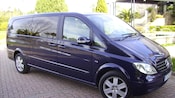 A minivan parked in front of a fountain