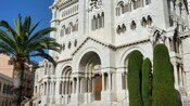 Grande igreja construída de blocos com arcadas decorativas e colunas ao redor de entradas e janelas