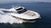 Prestige 500 52 foot yacht soars across the water off a populated coast