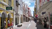 Tourists stroll and window shop their way down an outdoor shopping corridor for pedestrians only