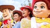 Woody and Jesse from Toy Story pose with a teen girl and boy wearing cowboy hats