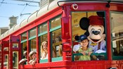 Conductor Mickey and a girl smile from the helm of a Red Car Trolley