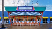 Blue-and-white-striped awning and bar chairs at Silver Screen Spirits Pool Bar