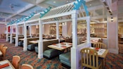 Booth seating under cabana-like structures inside the dining area at Cape May Café