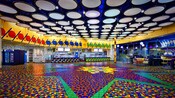 Vibrantly speckled floor and trim in primary colors with bright white overhead lights