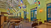 Área de comidas aireada y colorida con móviles coloridos que cuelgan de un techo alto en el restaurante The Artist's Palette