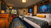 Royal beds, tall elaborate headboards, decorative throws and pillows, elegant dresser, curtained window