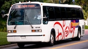 Un autobús blanco que dice "Transporte de Disney" al costado y el destino "Hollywood Studios" en la ventana delantera